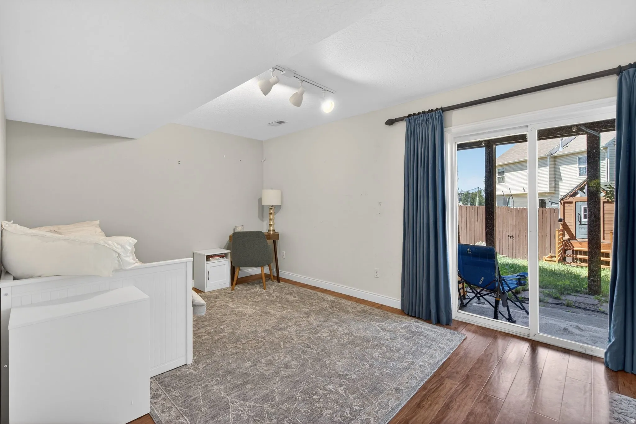 Room featuring sliding glass door access to the outdoor space, wood-finish flooring, recessed lighting, and track lighting