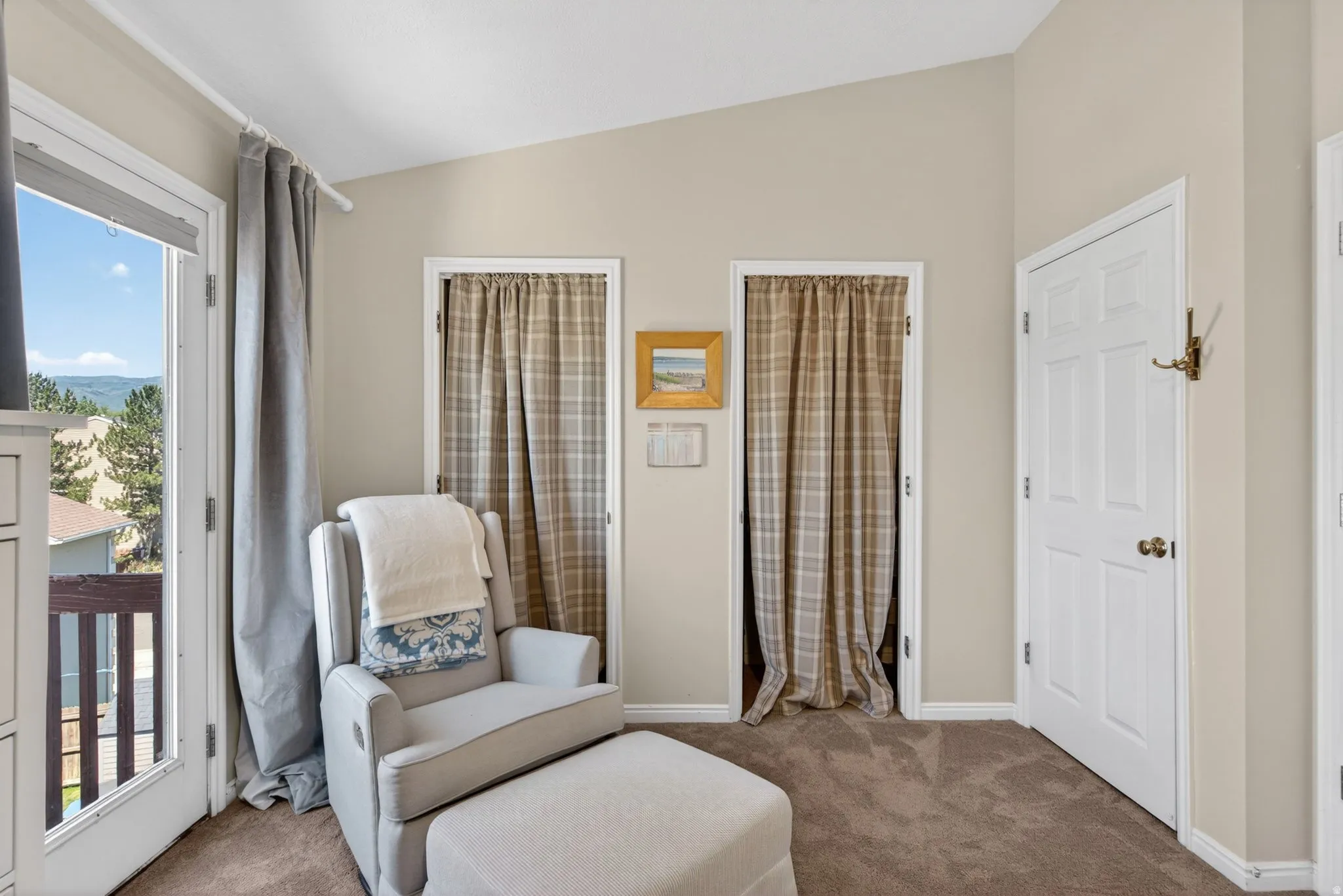 Room featuring a balcony door, sloped ceiling, and plush carpet flooring