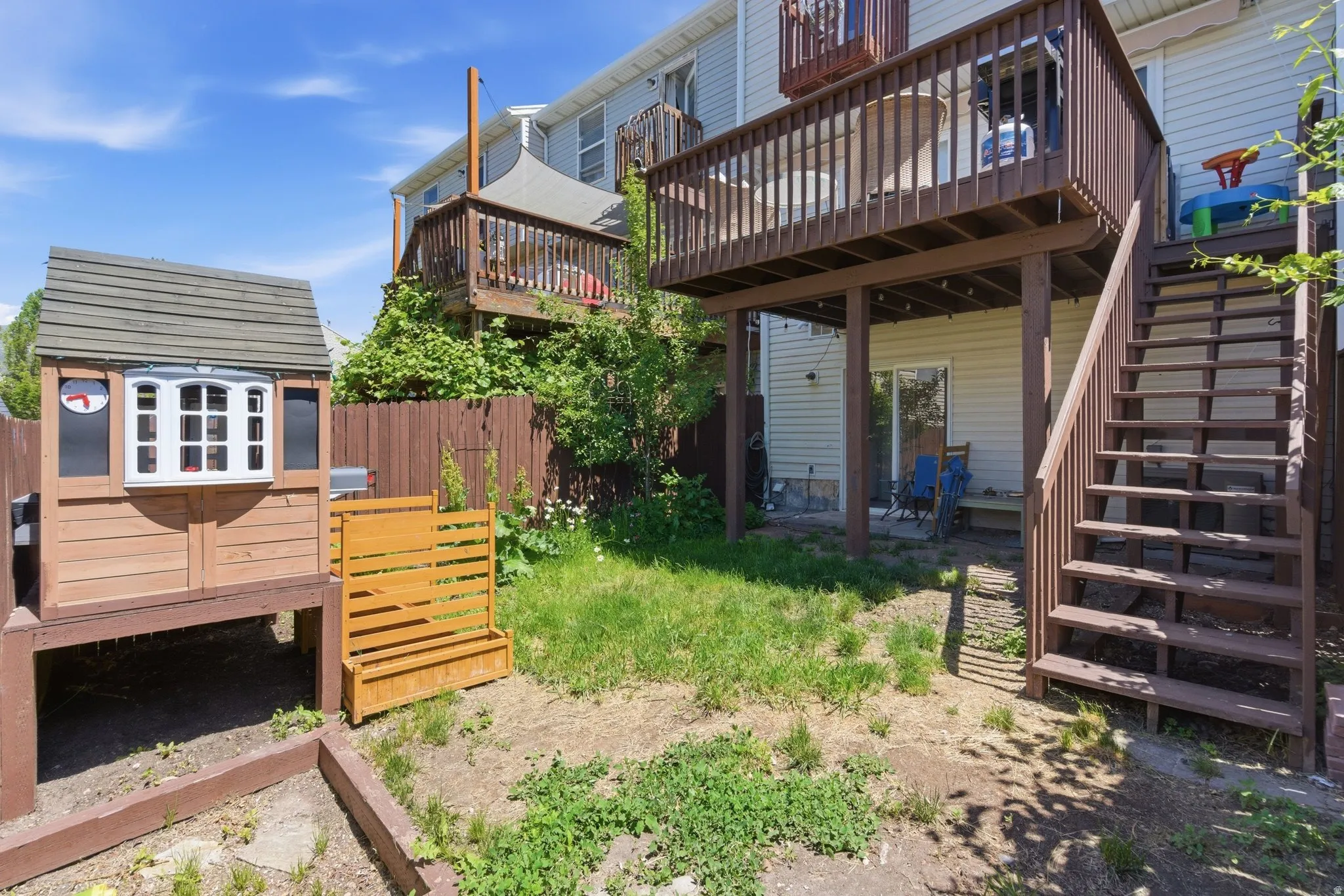 Tiered outdoor decks with wood railings, integrated staircase, and ample space for outdoor seating