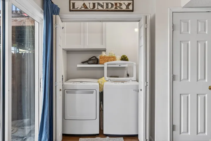 Dedicated laundry area featuring bifold doors, built-in upper cabinetry, and an integrated shelf