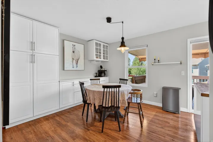 Kitchen featuring wood-finish flooring, white cabinetry, and a window with outdoor deck views