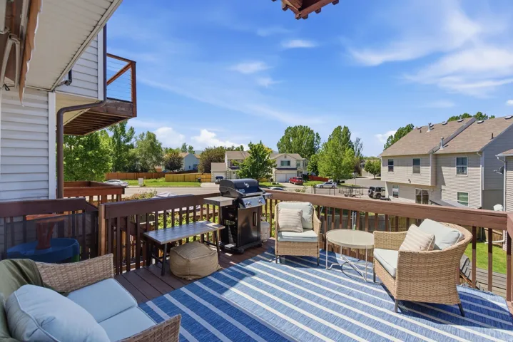 Spacious outdoor deck featuring wood decking, a full-height railing system, and a partial second-story balcony