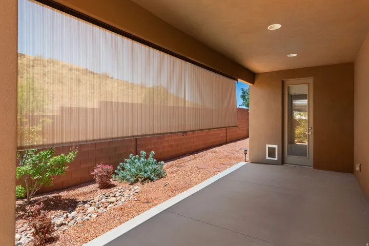 Covered patio featuring recessed lighting, a full-light exterior door, and a retractable privacy screen
