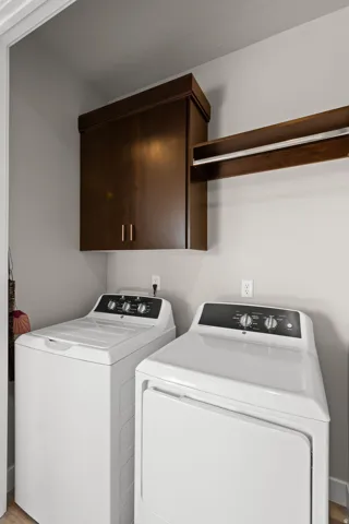 Laundry area featuring dark wood cabinetry and a clothes rod for convenience