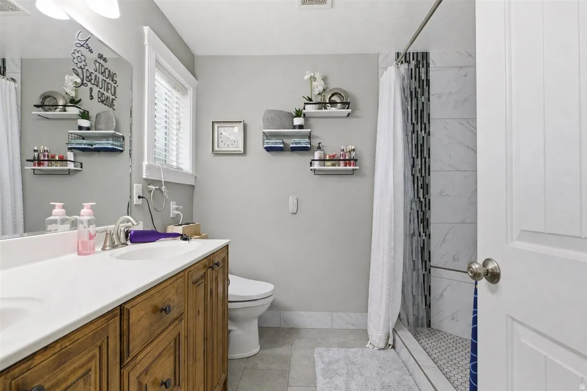 Bathroom featuring a wood-finish vanity with a white countertop and dual integrated sinks