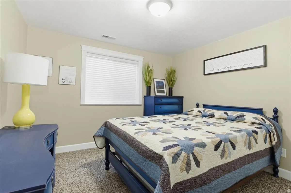 Recessed window with white blinds, neutral wall paint, and light-colored carpeting