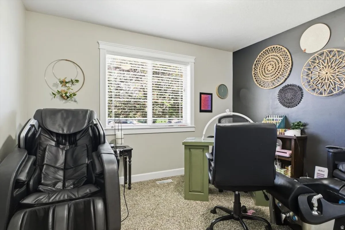 Carpeted room featuring a window with white blinds and trim, a contrasting dark accent wall, and recessed lighting