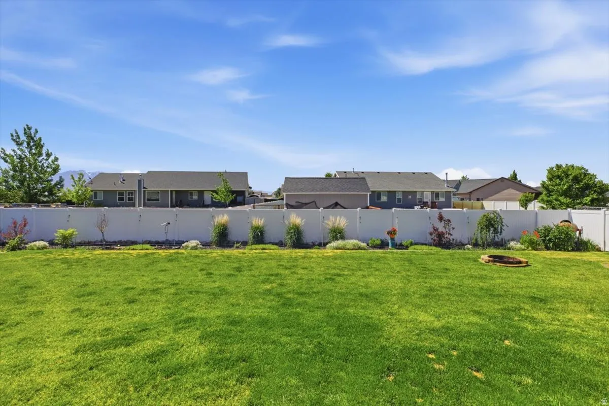 Expansive green lawn with a white privacy fence