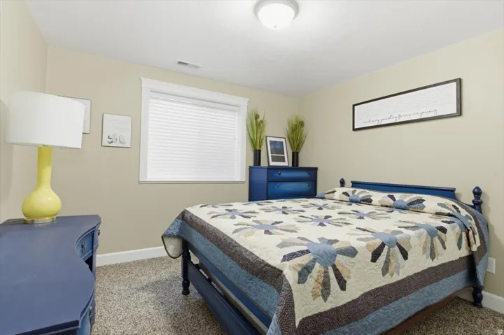 Recessed window with white blinds, neutral wall paint, and light-colored carpeting