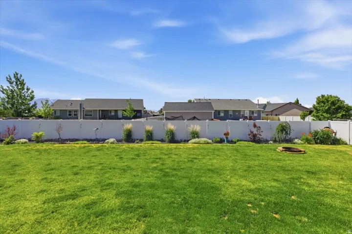 Expansive green lawn with a white privacy fence