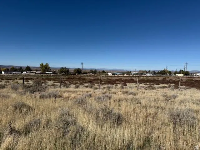 Expansive undeveloped land featuring natural vegetation and partial fencing