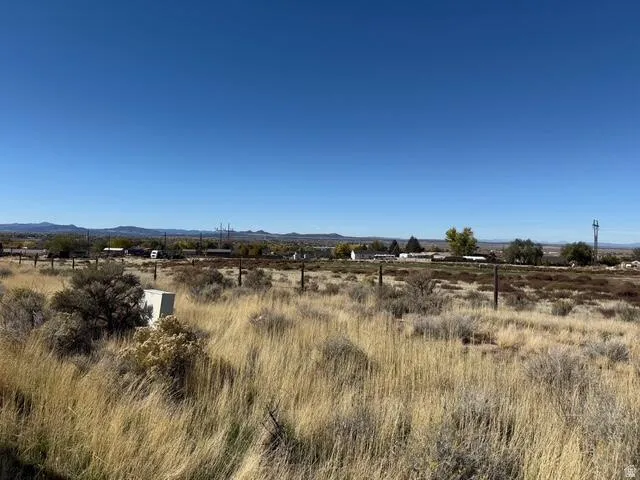 Expansive open land featuring natural grasses and sparse brush