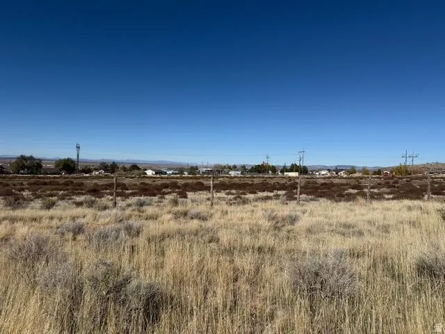 Expansive undeveloped land featuring natural grasses and sparse brush