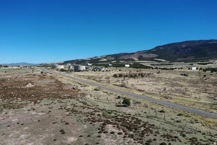 Expansive rural landscape featuring a paved road traversing open terrain