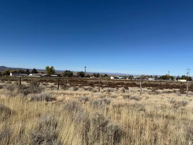 Expansive undeveloped land featuring natural vegetation and fencing