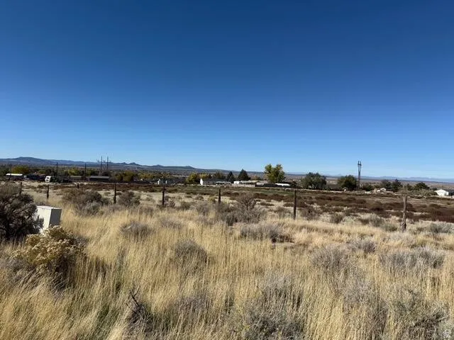 Expansive undeveloped land with natural vegetation and distant mountain ranges