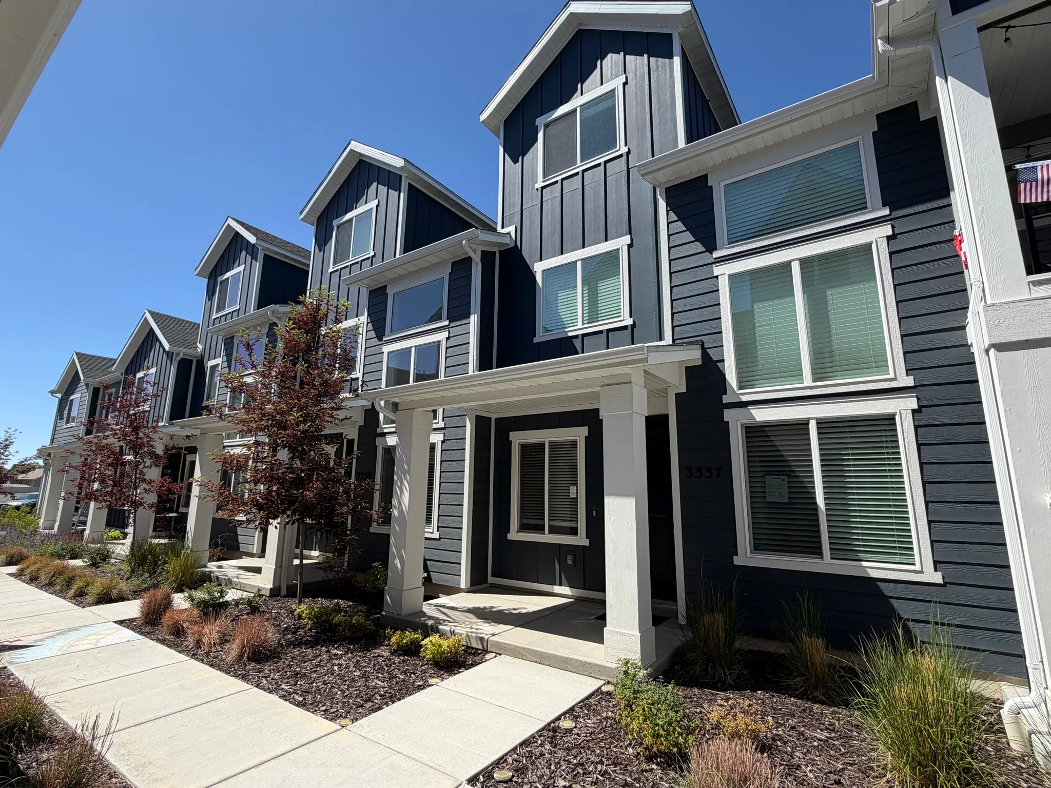 Modern townhome exterior featuring multi-level architecture with a dark gray vertical and horizontal siding facade