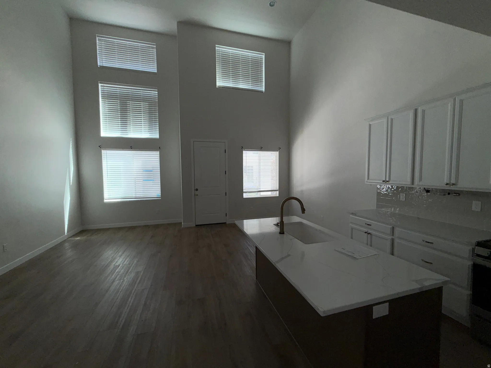Open-concept living area with soaring ceilings and wood-finish flooring