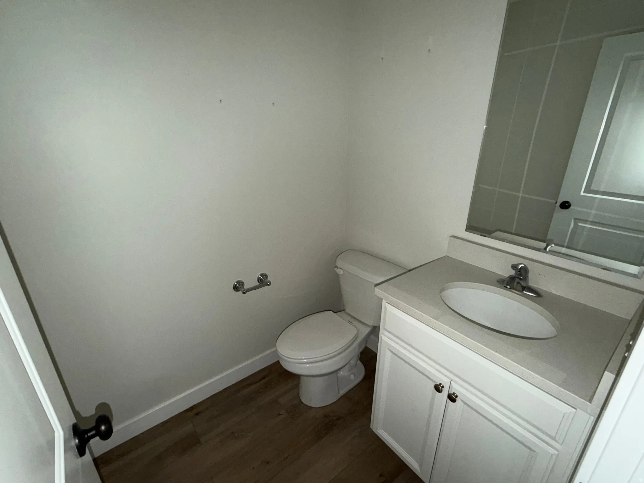 Bathroom featuring a white vanity with a light-toned countertop, oval undermount sink, and chrome faucet