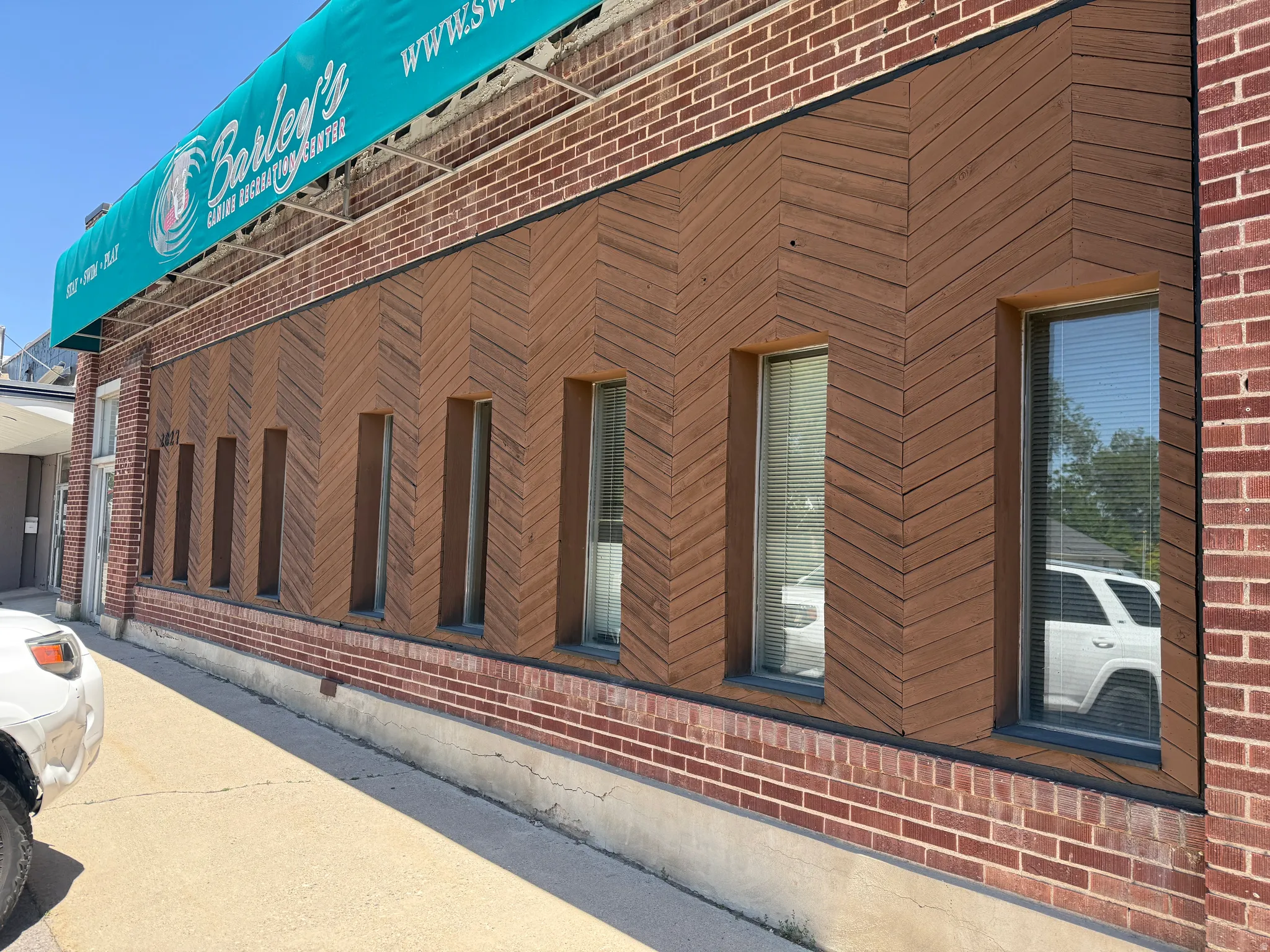 Brick facade building with a prominent brown wood-finish chevron pattern accent wall
