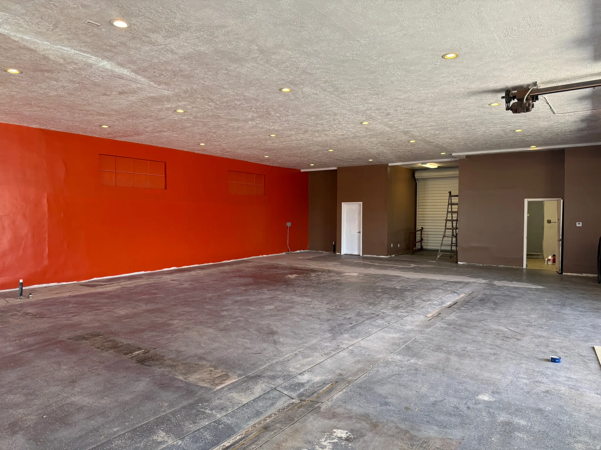 Spacious interior featuring a concrete floor, recessed lighting, and a roll-up door