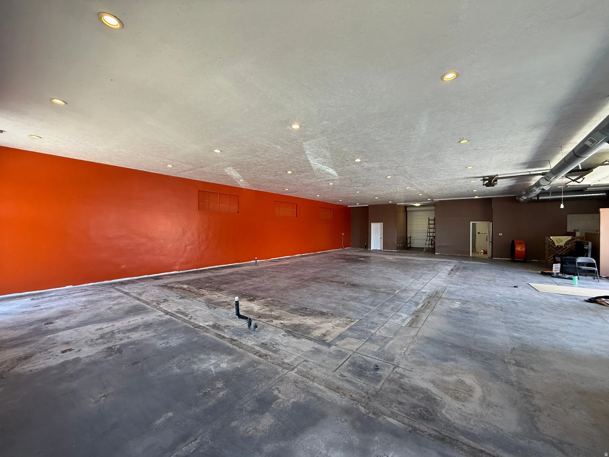 Spacious interior with exposed ceiling ductwork and recessed lighting