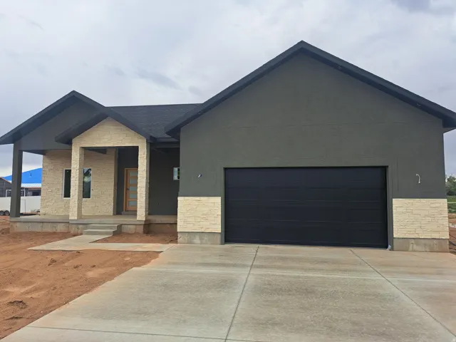 Modern exterior featuring dark gray stucco and light-toned stone accents