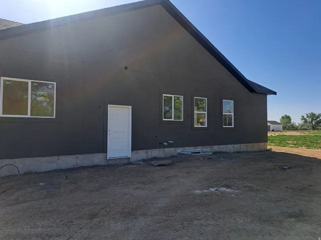 Modern exterior featuring dark gray siding and white-trimmed windows