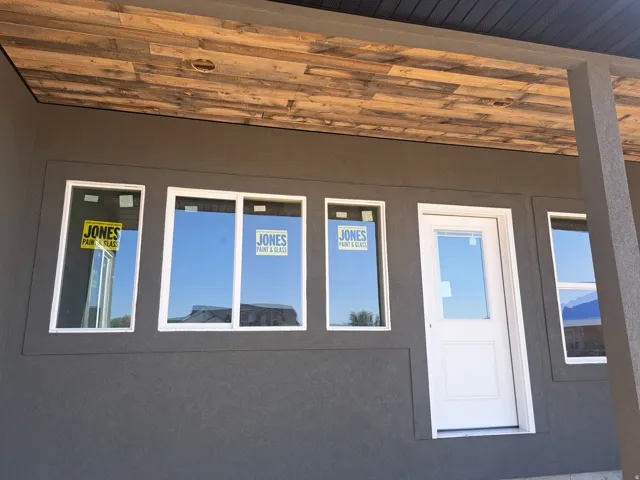 Exterior featuring a textured dark gray stucco finish and a wood-panel ceiling