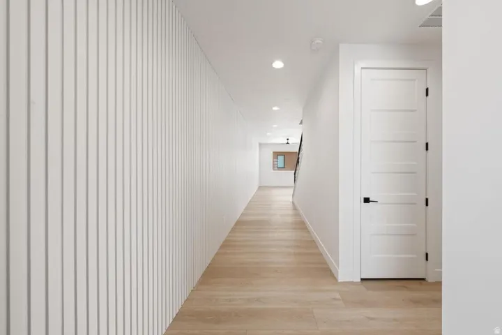 Long hallway with light wood-finish flooring