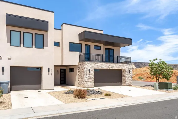 Modern exterior featuring a prominent second-story balcony with metal railings