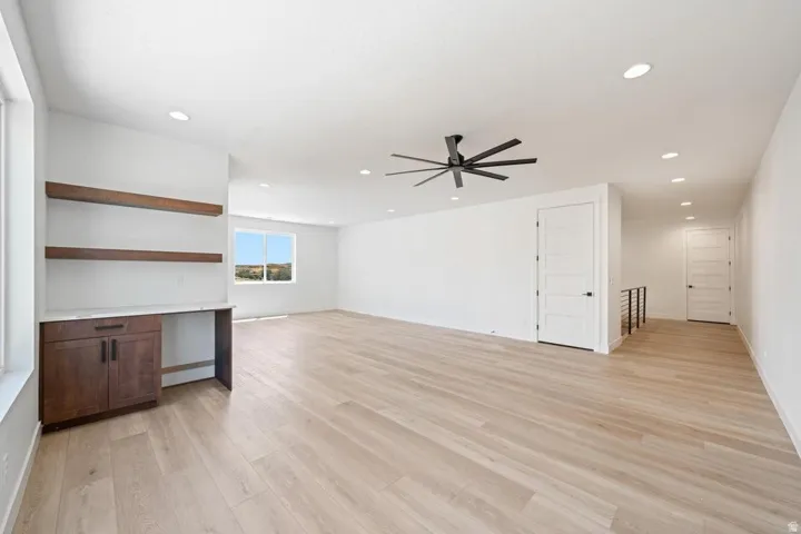 Expansive open-concept room featuring light wood-finish flooring and recessed lighting