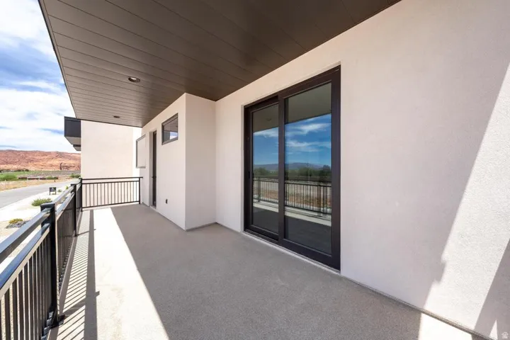 Private balcony featuring a concrete surface, black metal railings, and a dark soffit ceiling with recessed lighting