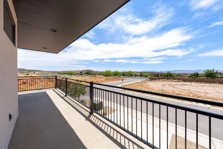 Spacious outdoor balcony with durable concrete flooring and a black metal railing