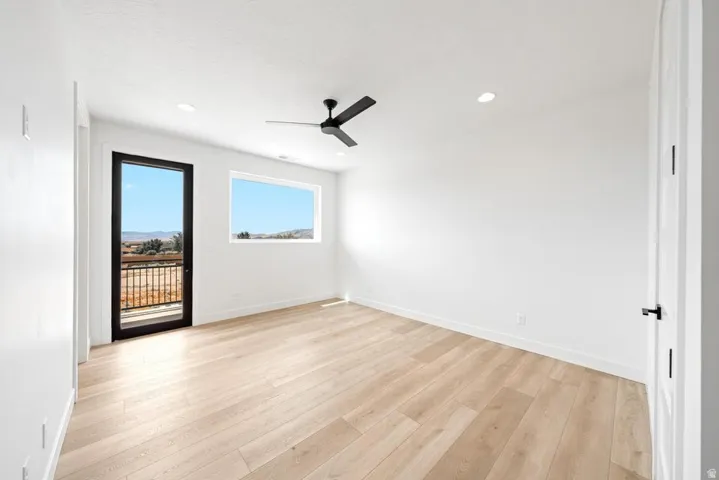 Light wood-finish flooring complements white walls and recessed lighting