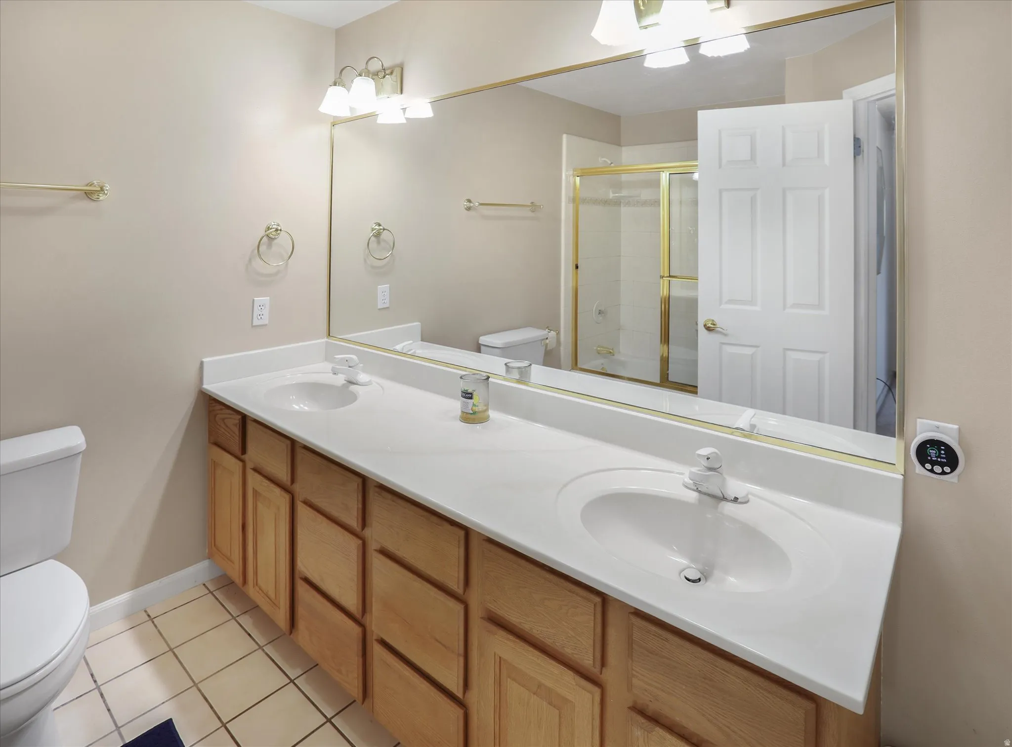 Double vanity with dual undermount sinks, expansive countertop, and natural wood cabinetry