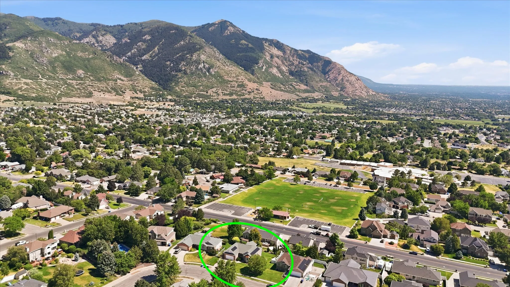 Aerial perspective showcasing a residential neighborhood with mountain scenery
