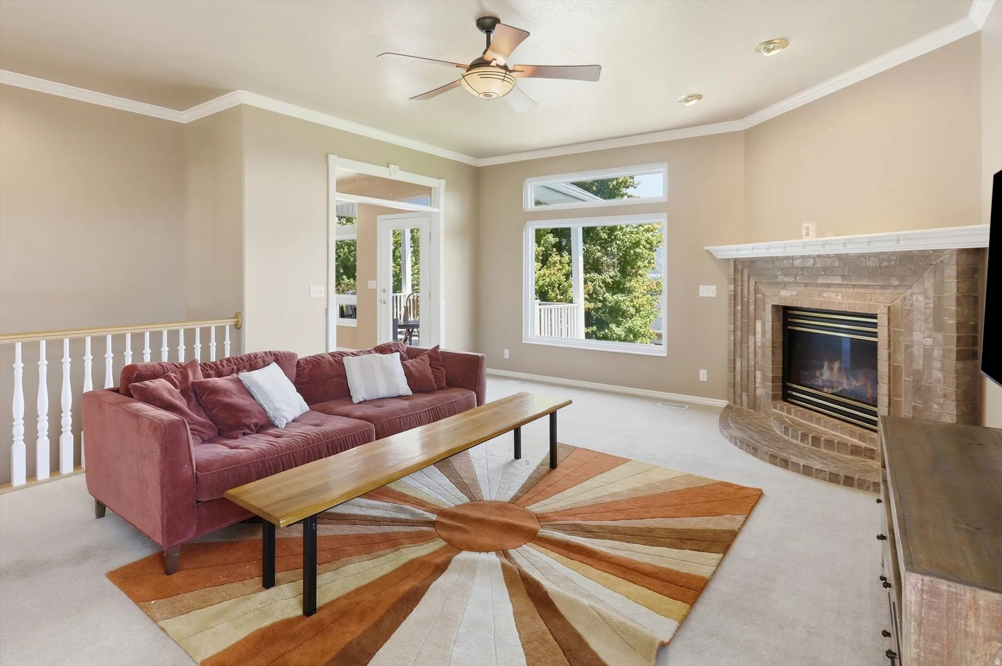 Living area featuring a floor-to-ceiling brick fireplace with hearth, a multi-pane window with upper transom, recessed lighting, and a ceiling fan