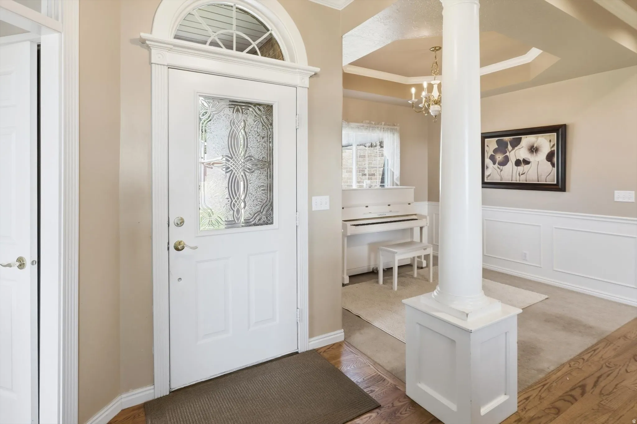 Entryway featuring a white door with decorative glass inserts and an arched transom window