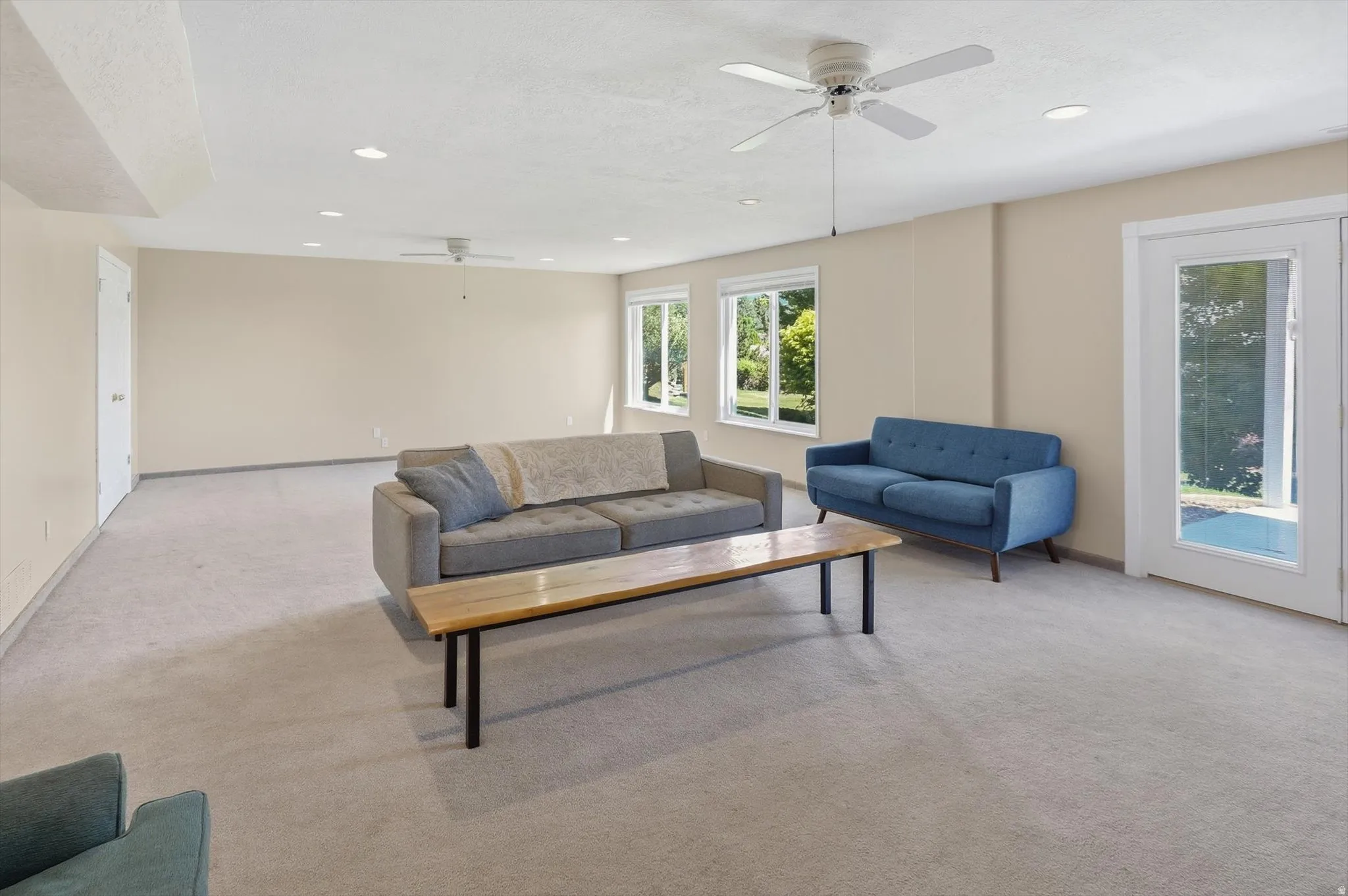 Spacious room featuring light-colored carpet flooring, recessed lighting, and multiple ceiling fans