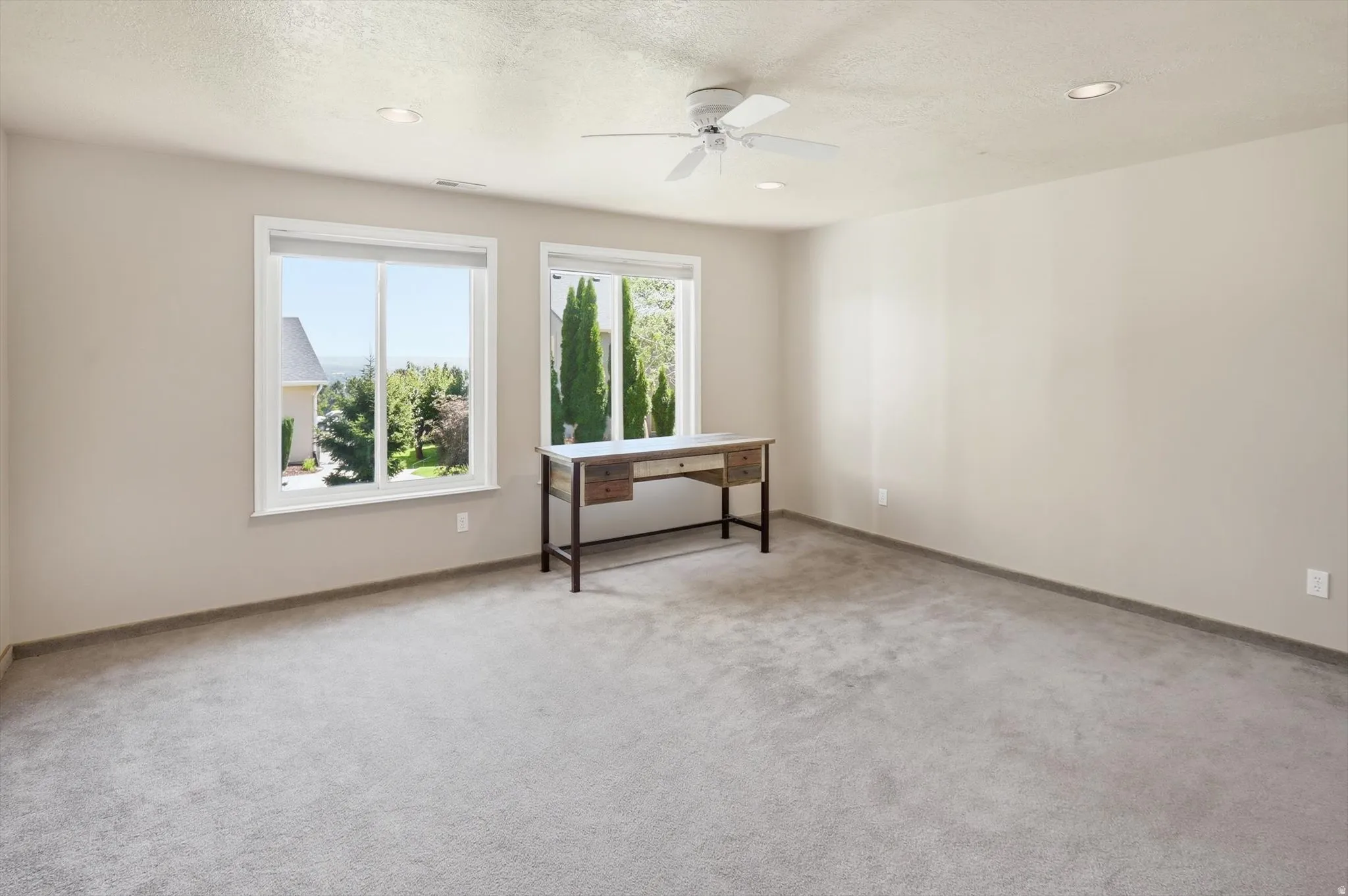 Spacious room featuring neutral carpeting and light-toned walls