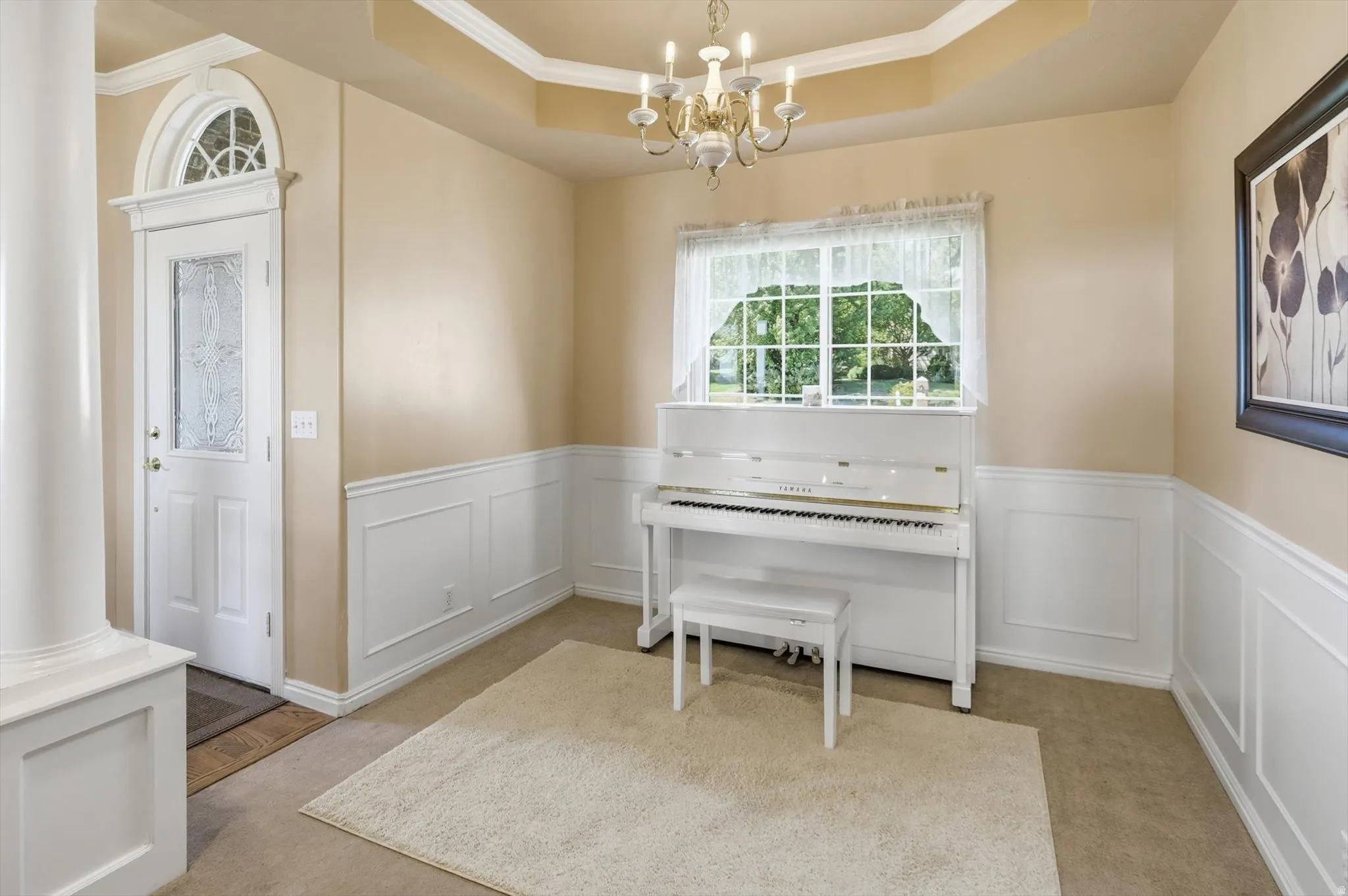 Entryway featuring a decorative front door with an arched transom, a fluted column, and wainscoting