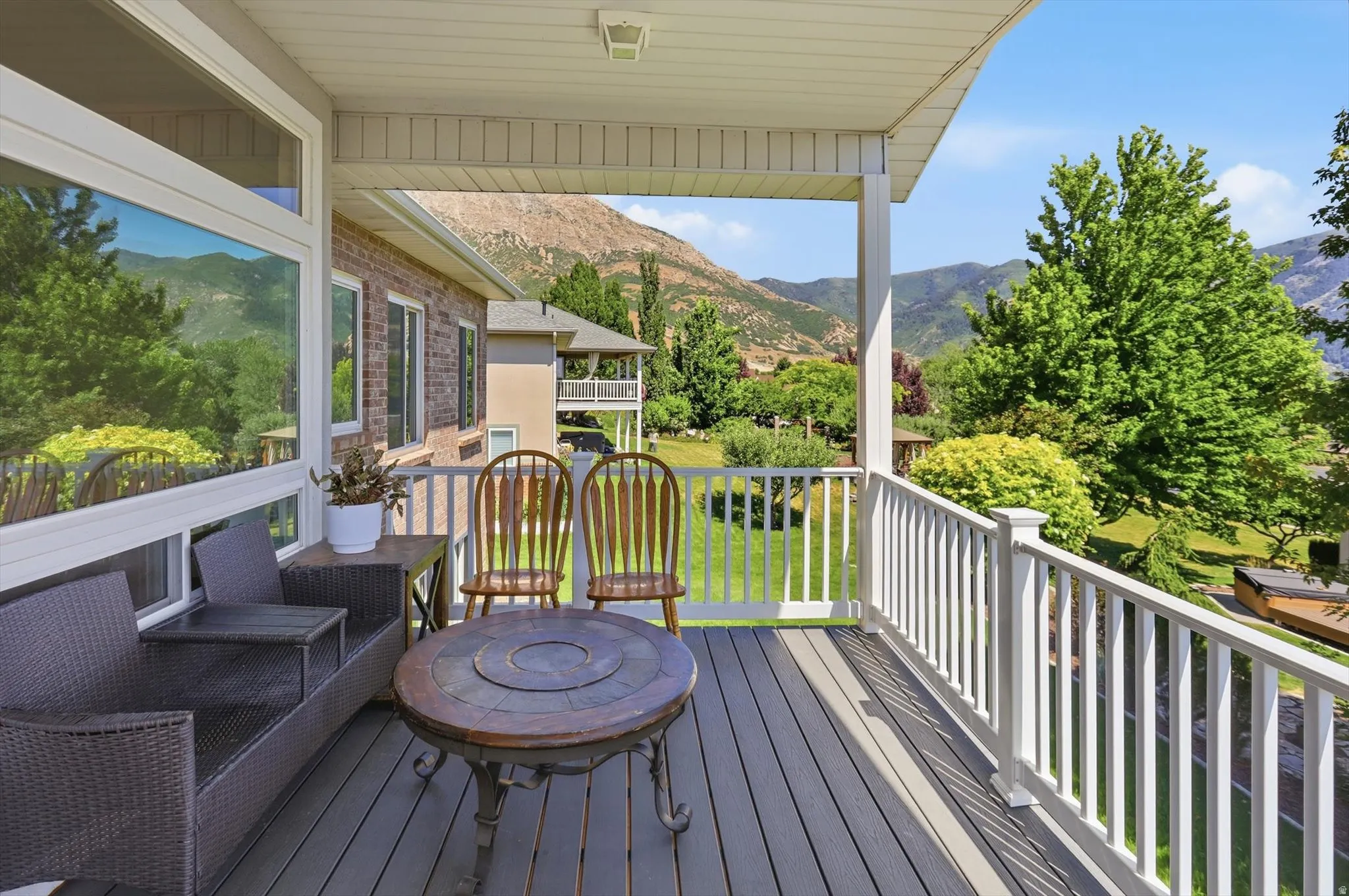 Covered outdoor deck featuring composite decking and white railings