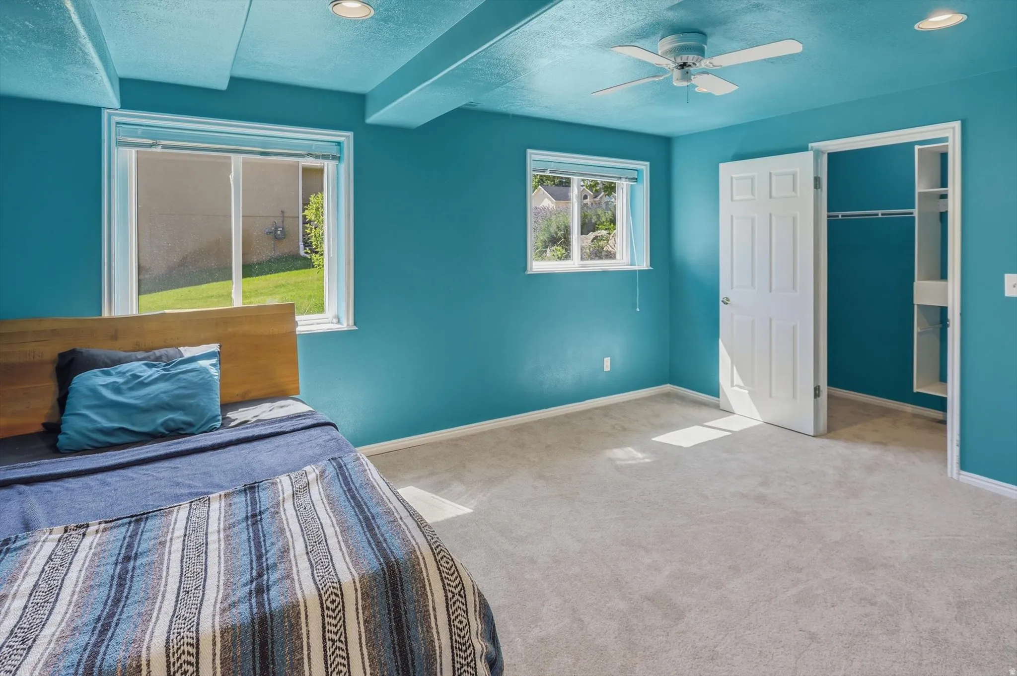 Carpeted room featuring two windows, a ceiling fan, recessed lighting, and a closet with built-in shelving