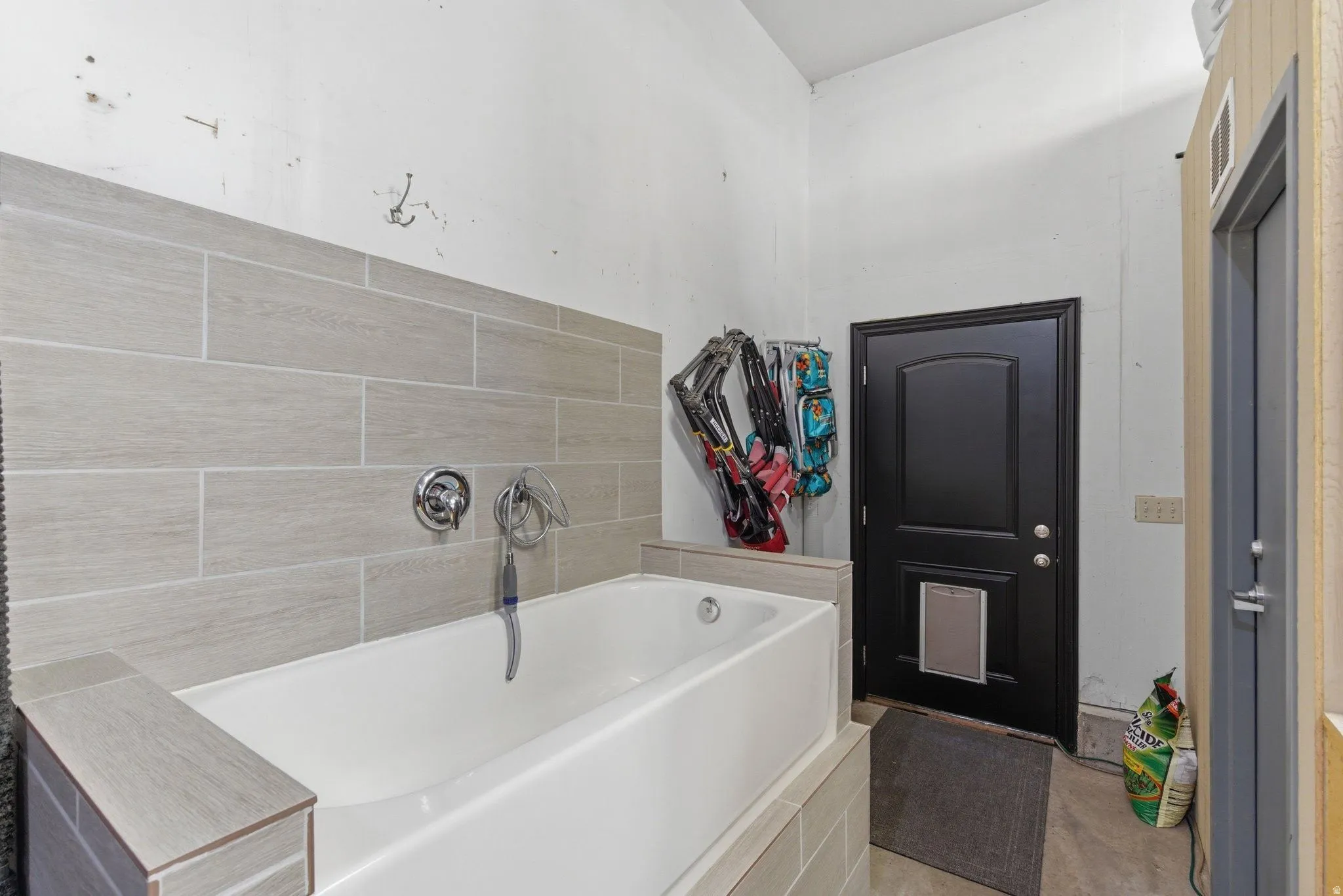Utility tub with chrome fixtures and light-toned tile surround