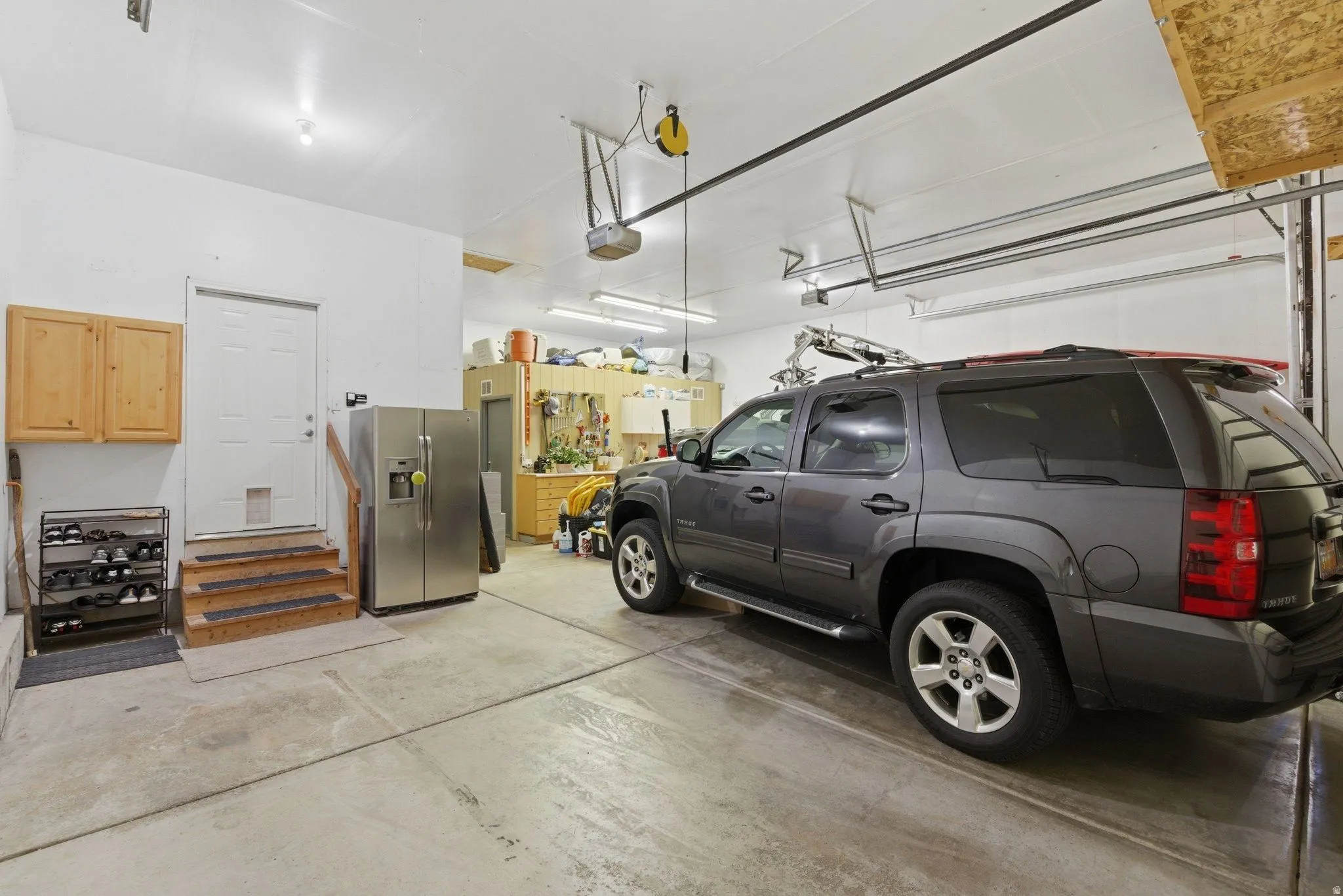 Spacious garage with exposed rafter ceiling and concrete flooring