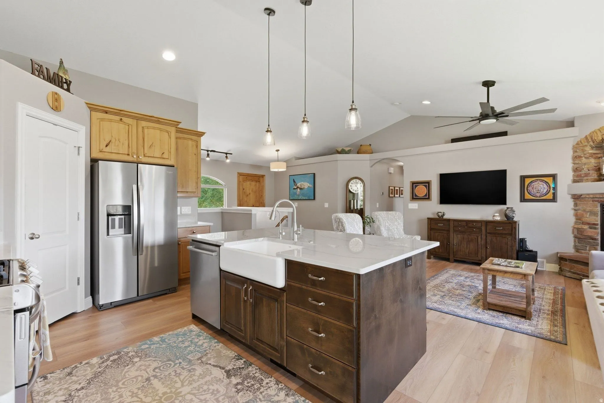 Kitchen island with a white farmhouse sink, quartz countertop, and dark wood-finish cabinetry