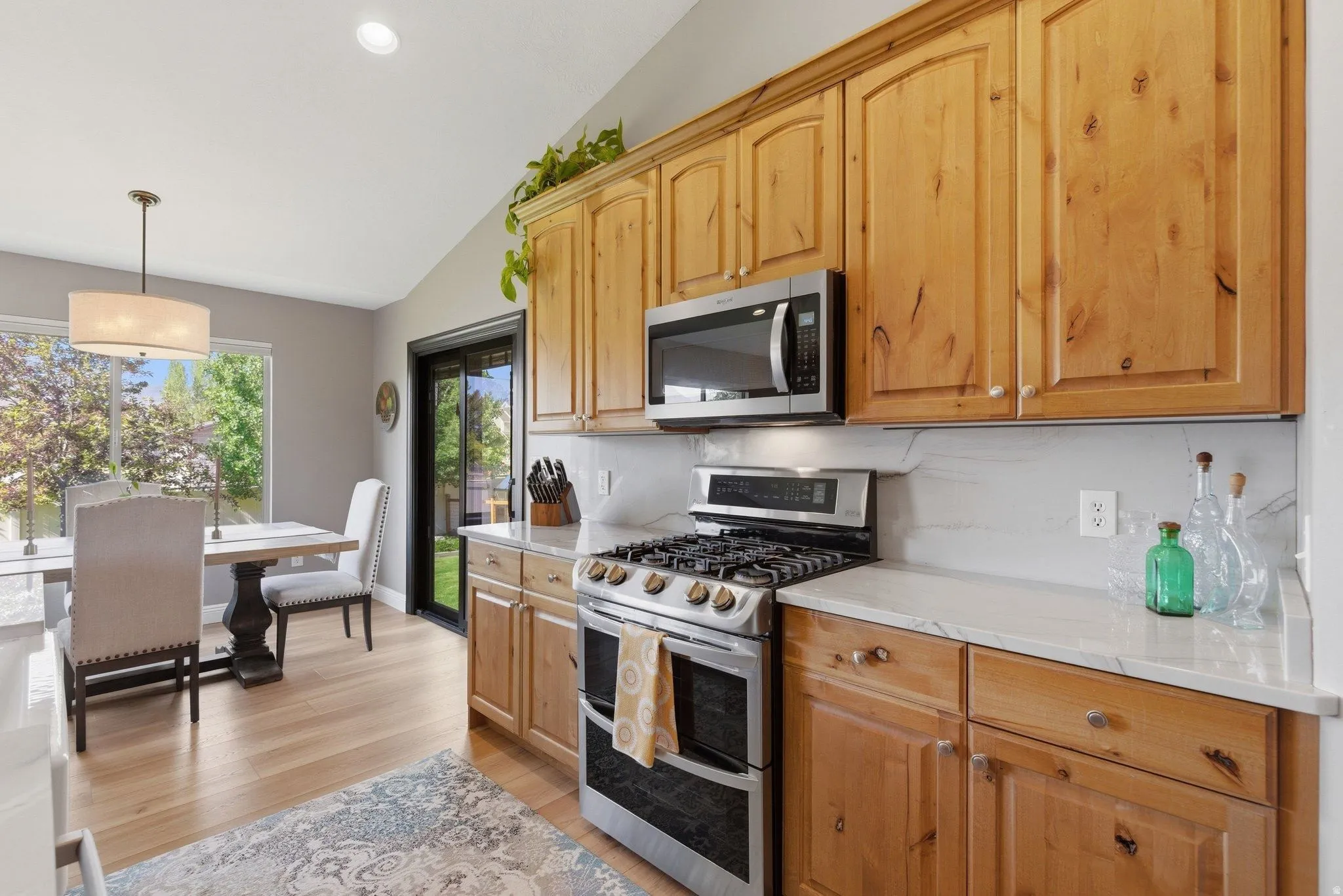 Kitchen featuring light wood cabinetry, stainless steel appliances, and white countertops