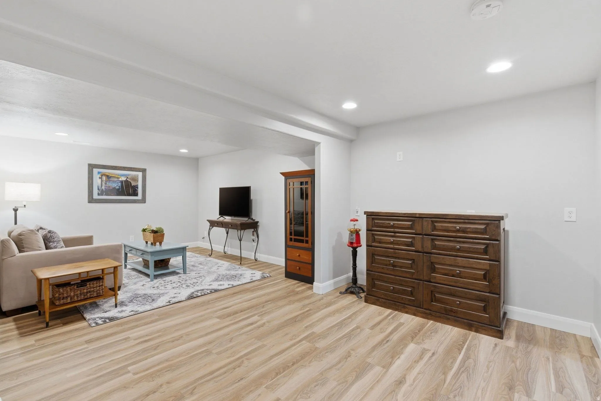 Spacious living area featuring light wood-finish flooring and recessed ceiling lighting