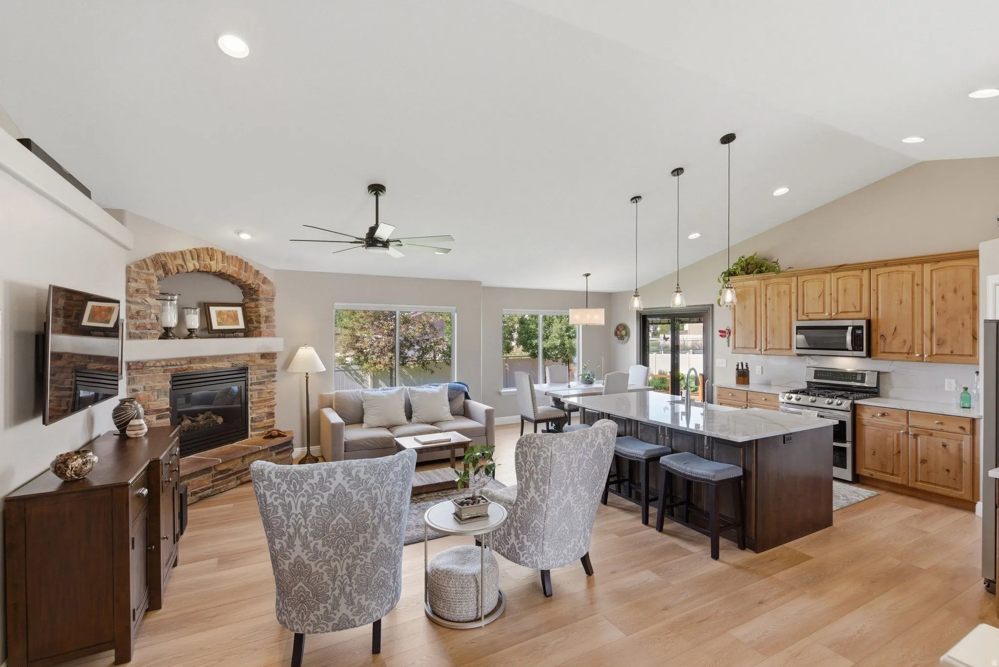 Open-concept living space featuring wood-finish flooring and vaulted ceilings